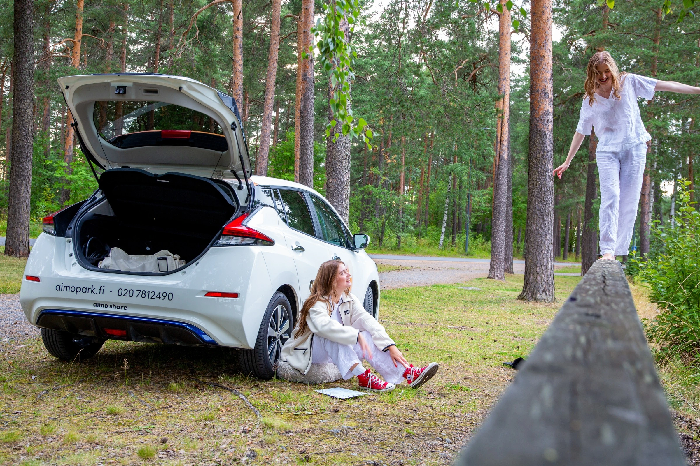 Kaksi ihmistä ja auto metsässä