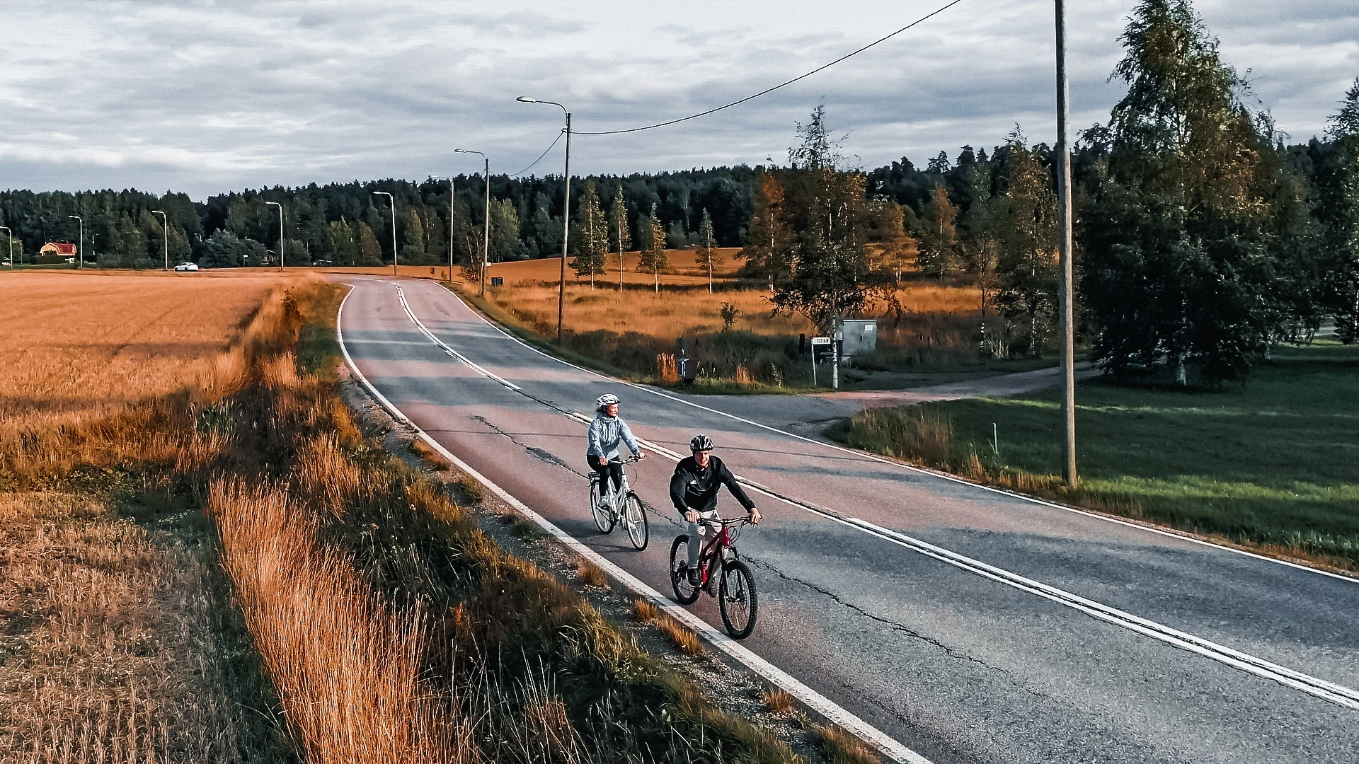 Pyöräilijät maalaismaisemassa